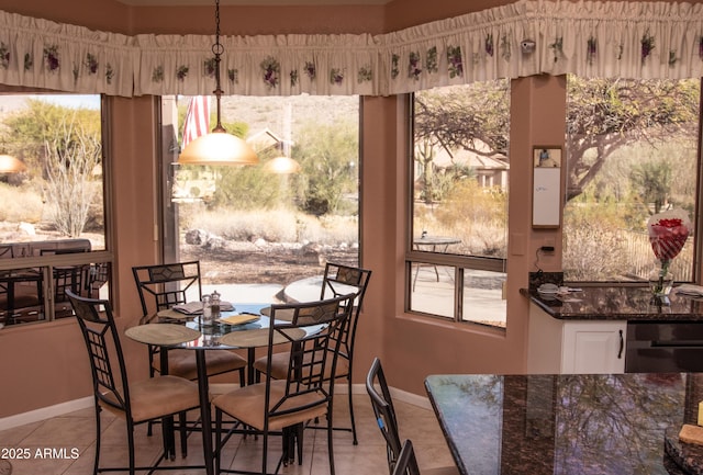 dining room with light tile patterned flooring, a wealth of natural light, and baseboards