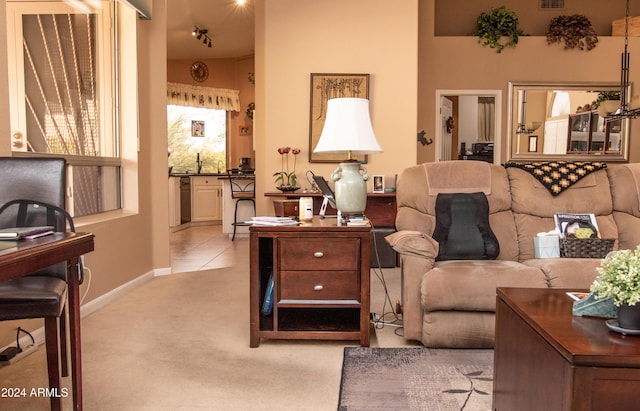 living area featuring baseboards, visible vents, and light colored carpet