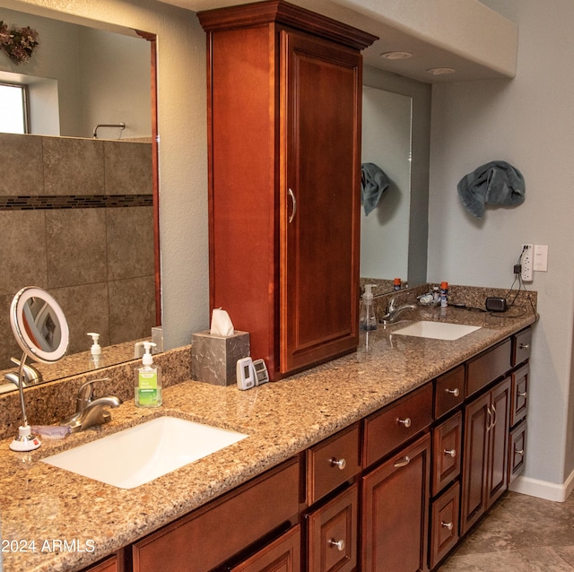 full bath featuring a sink, baseboards, and double vanity