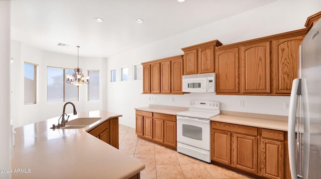 kitchen with hanging light fixtures, a chandelier, light tile patterned flooring, sink, and white appliances