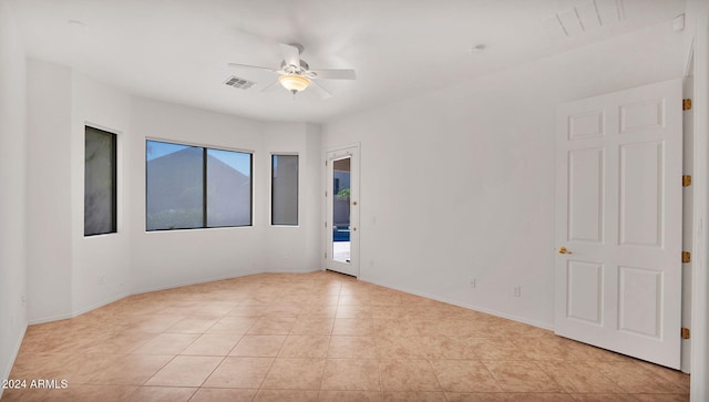 spare room with ceiling fan and light tile patterned floors