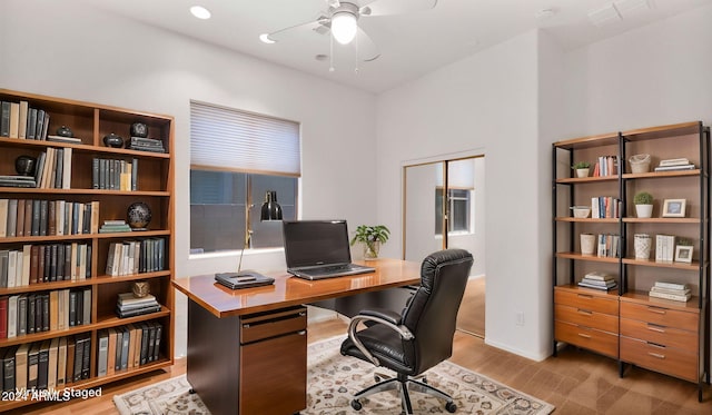 office with ceiling fan and light hardwood / wood-style flooring