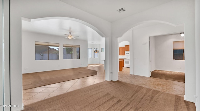 unfurnished room with ceiling fan with notable chandelier and light tile patterned floors