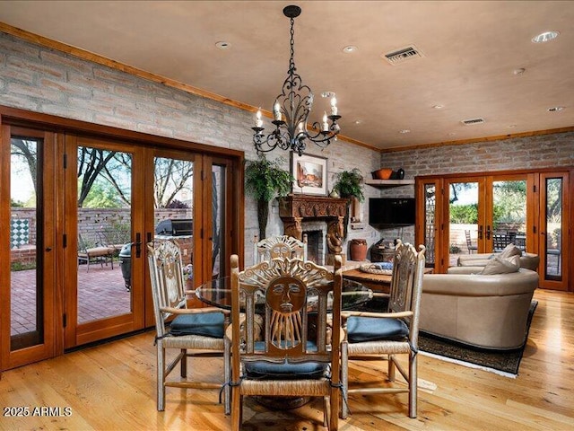8022 N Ironwood Dr, Paradise Valley, AZ 85253 - dining area with french doors, brick wall, healthy amount of natural light, light wood finished floors, and crown molding