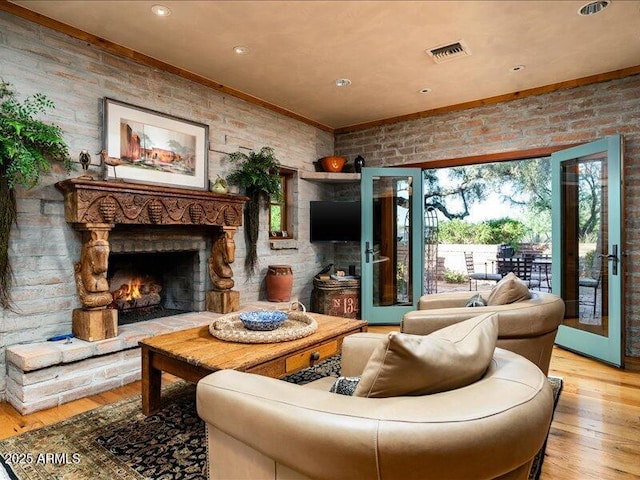 8022 N Ironwood Dr, Paradise Valley, AZ 85253 - living room with wood finished floors, a warm lit fireplace, ornamental molding, brick wall, and recessed lighting