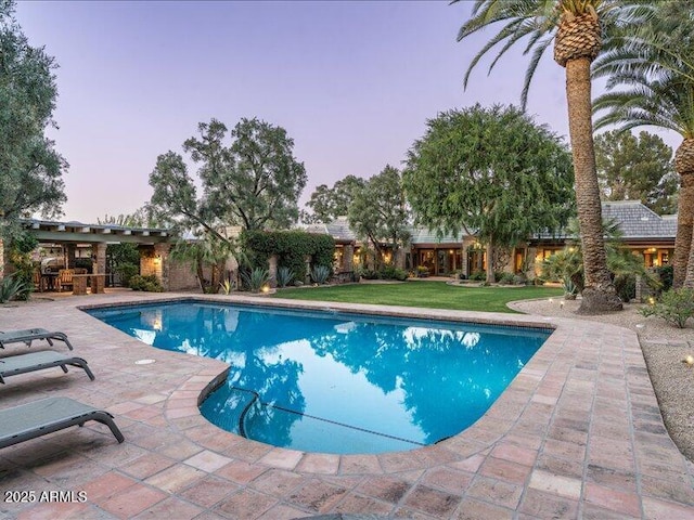 8022 N Ironwood Dr, Paradise Valley, AZ 85253 - pool at dusk featuring a patio and a lawn