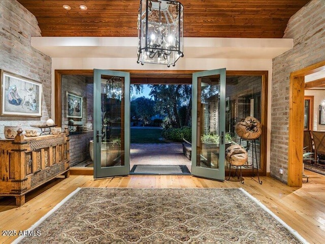 8022 N Ironwood Dr, Paradise Valley, AZ 85253 - foyer entrance featuring french doors, wood ceiling, hardwood / wood-style flooring, a chandelier, and brick wall