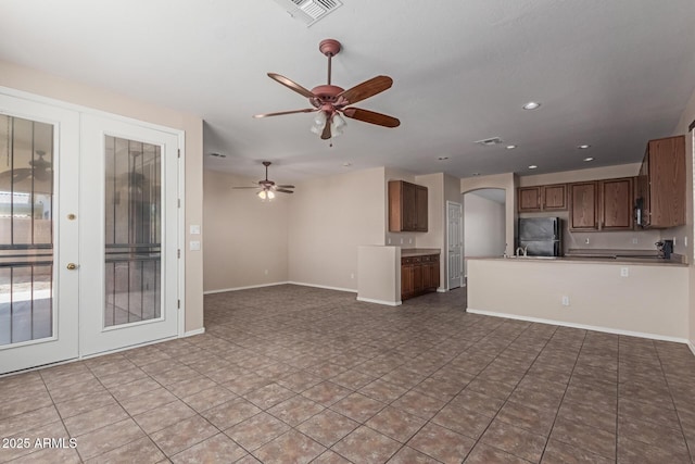 unfurnished living room featuring visible vents, baseboards, ceiling fan, french doors, and arched walkways