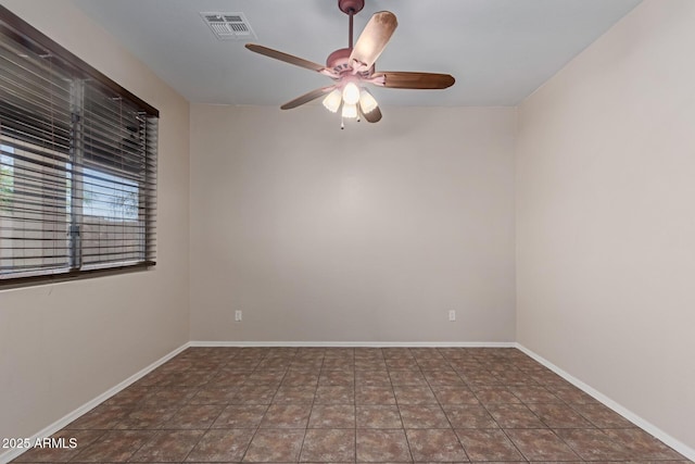 tiled spare room featuring visible vents, baseboards, and ceiling fan