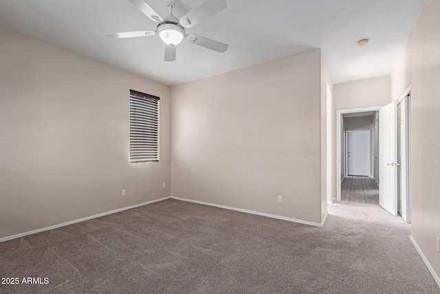 carpeted empty room featuring baseboards and ceiling fan