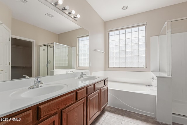 full bath featuring a sink, a garden tub, a shower stall, and tile patterned floors