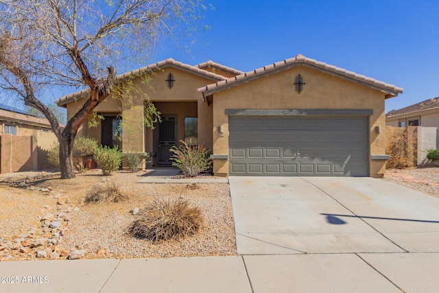 view of front of house with a tile roof, a garage, driveway, and stucco siding