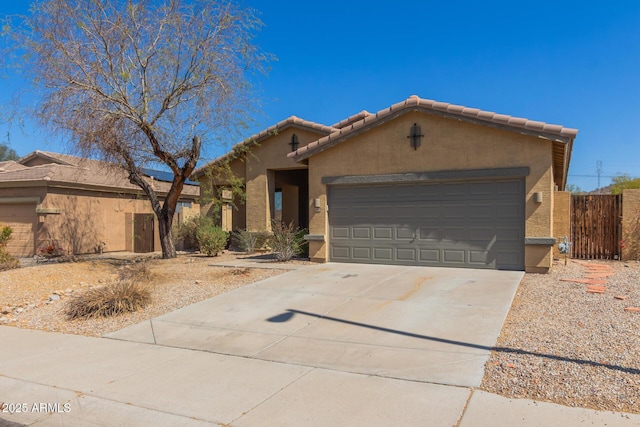 view of front of property with stucco siding, fence, concrete driveway, an attached garage, and a tiled roof