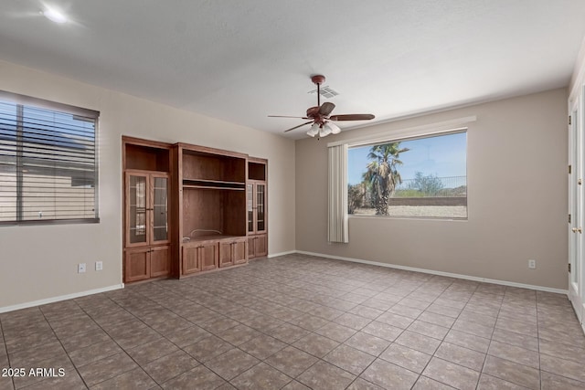 tiled spare room with baseboards and ceiling fan