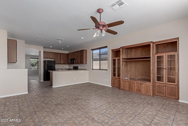 kitchen featuring visible vents, baseboards, ceiling fan, arched walkways, and black appliances