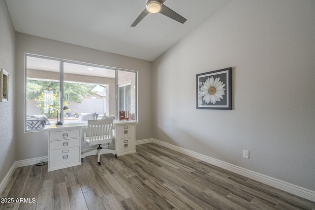 home office featuring wood finished floors, vaulted ceiling, a ceiling fan, and baseboards