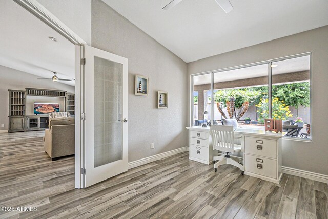 home office with ceiling fan, lofted ceiling, french doors, wood finished floors, and baseboards