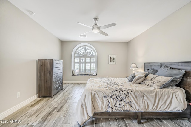 bedroom with light wood-style floors, baseboards, and ceiling fan