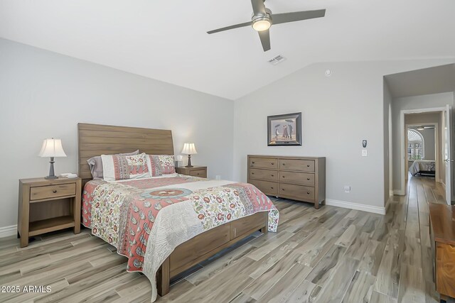 bedroom with light wood-style floors, vaulted ceiling, baseboards, and a ceiling fan