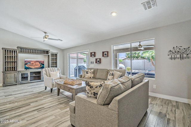 living room with a ceiling fan, wood finished floors, baseboards, and vaulted ceiling