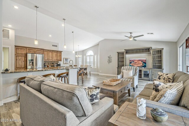 living area with lofted ceiling, light wood-style floors, ceiling fan, baseboards, and recessed lighting