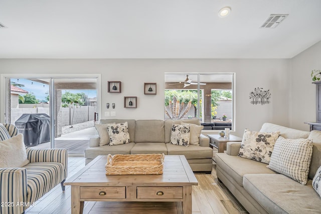 living room with plenty of natural light, light wood-type flooring, recessed lighting, and a ceiling fan