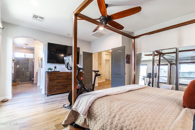 bedroom featuring arched walkways, ceiling fan, visible vents, and light wood-style floors