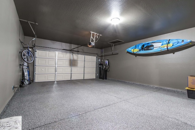 garage with a garage door opener and baseboards