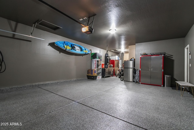 garage featuring a garage door opener and freestanding refrigerator