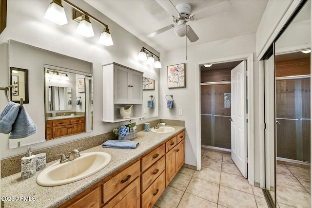 full bath with a stall shower, tile patterned floors, a sink, and a ceiling fan