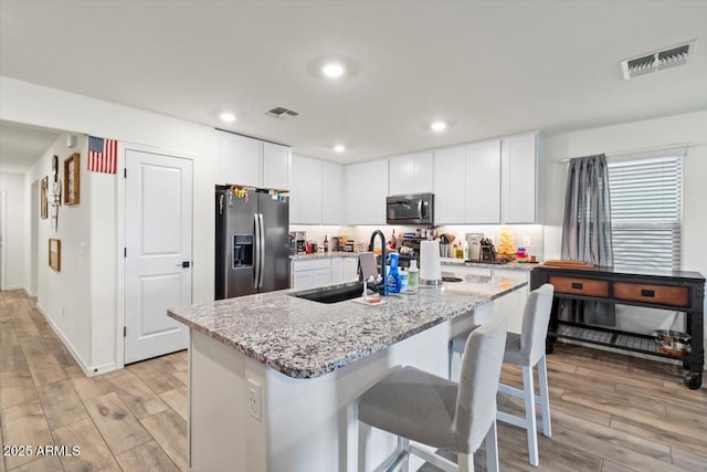 17461 W Molly Ln, Surprise, AZ 85387 - kitchen featuring stainless steel appliances, light wood-style floors, a sink, white cabinetry, and light stone counters