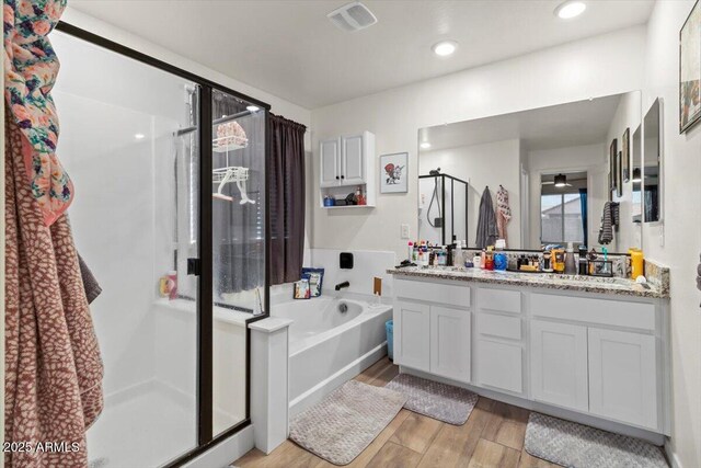 17461 W Molly Ln, Surprise, AZ 85387 - bathroom featuring a shower stall, double vanity, wood finished floors, and a bath
