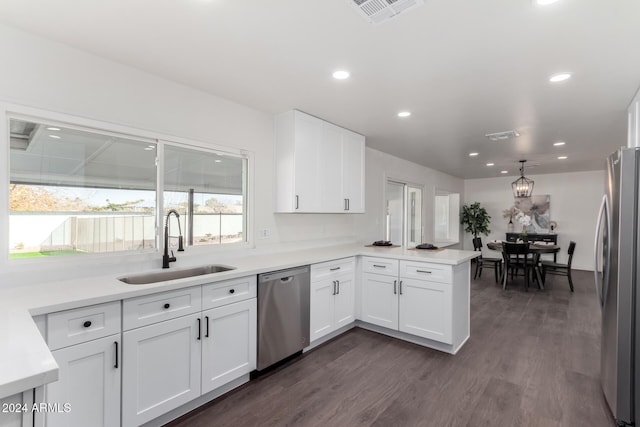 kitchen featuring kitchen peninsula, white cabinetry, sink, and stainless steel appliances