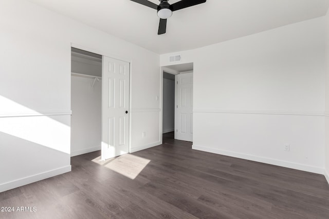 unfurnished bedroom featuring ceiling fan, dark hardwood / wood-style flooring, and a closet