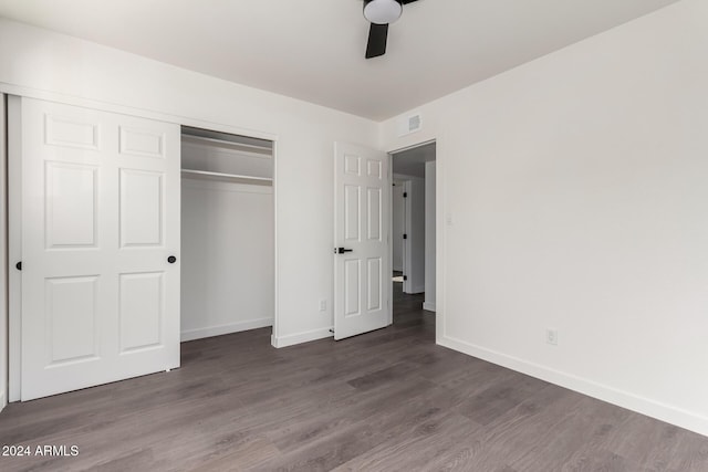 unfurnished bedroom with ceiling fan, dark hardwood / wood-style flooring, and a closet