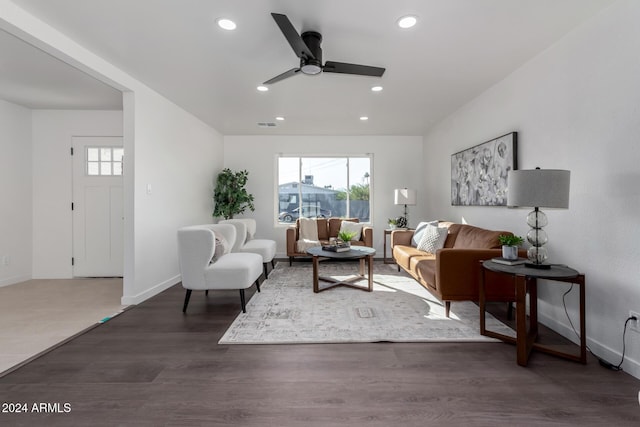 living room featuring ceiling fan and dark wood-type flooring