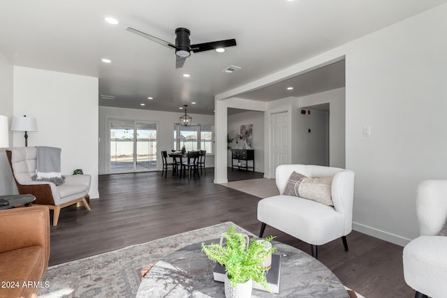 living room featuring ceiling fan and dark hardwood / wood-style floors