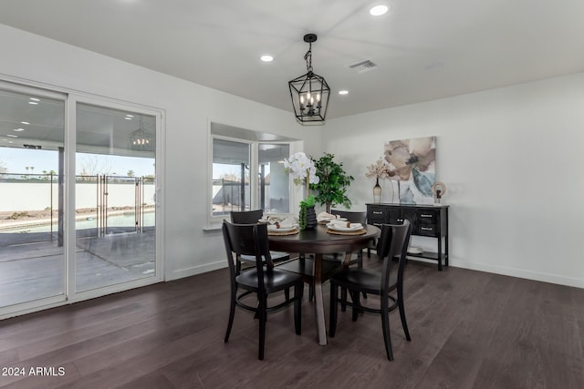 dining area with dark hardwood / wood-style flooring and a notable chandelier