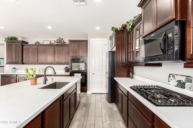 913 W Yosemite Dr, Chandler, AZ 85248 - kitchen with a sink, black appliances, light countertops, recessed lighting, and dark brown cabinets