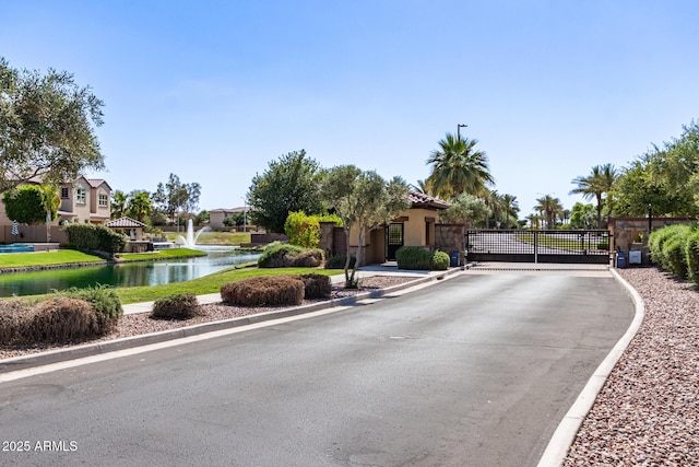 913 W Yosemite Dr, Chandler, AZ 85248 - view of asphalt street featuring a gate, a water view, and curbs