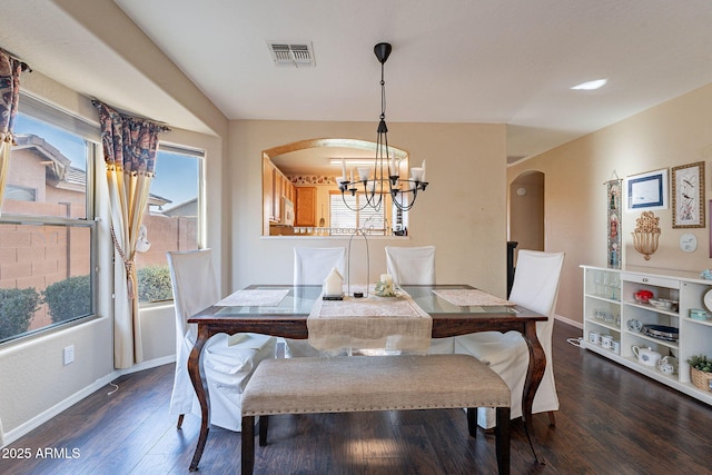 dining room featuring dark wood-type flooring and an inviting chandelier