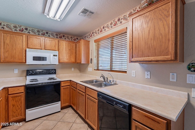 kitchen featuring light tile patterned floors, white appliances, a textured ceiling, and sink