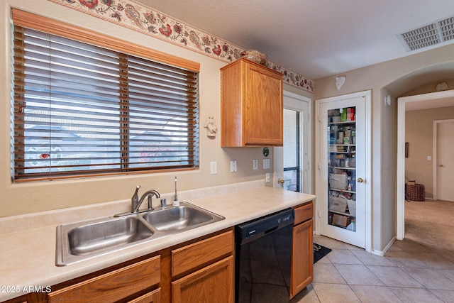 kitchen with dishwasher, light tile patterned floors, and sink