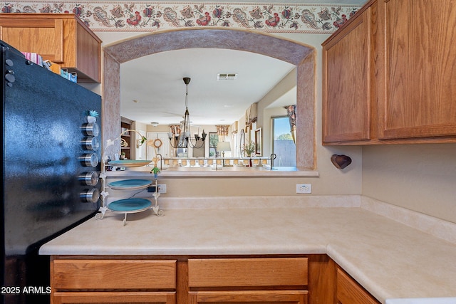 kitchen featuring a notable chandelier and black refrigerator