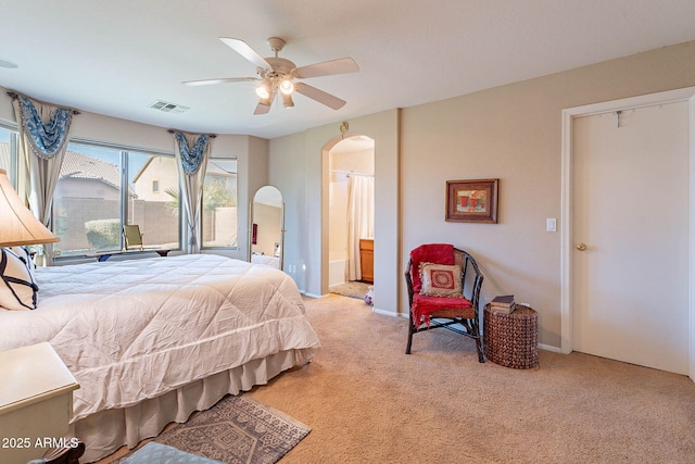 bedroom featuring connected bathroom, ceiling fan, and light carpet