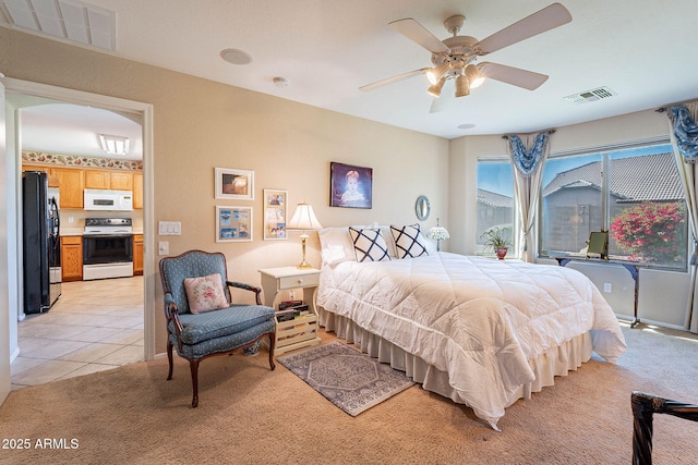 bedroom featuring ceiling fan, black refrigerator, and light tile patterned floors