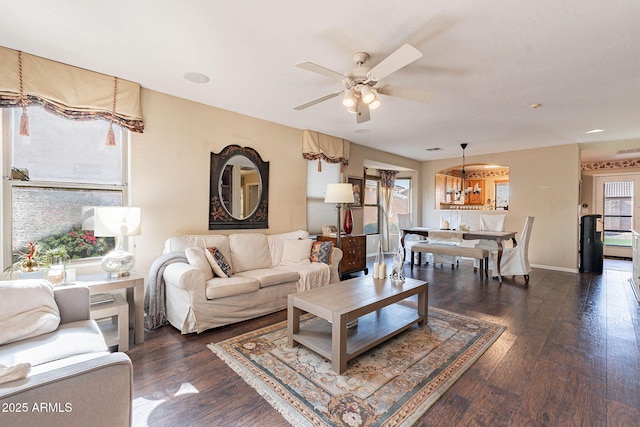 living room featuring ceiling fan and dark wood-type flooring