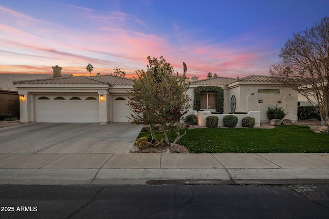 mediterranean / spanish home with a garage and a yard