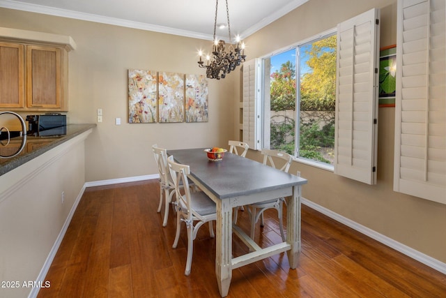 dining area featuring crown molding, dark hardwood / wood-style flooring, and a chandelier