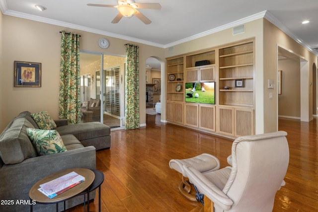 living room with ornamental molding, dark wood-type flooring, and ceiling fan